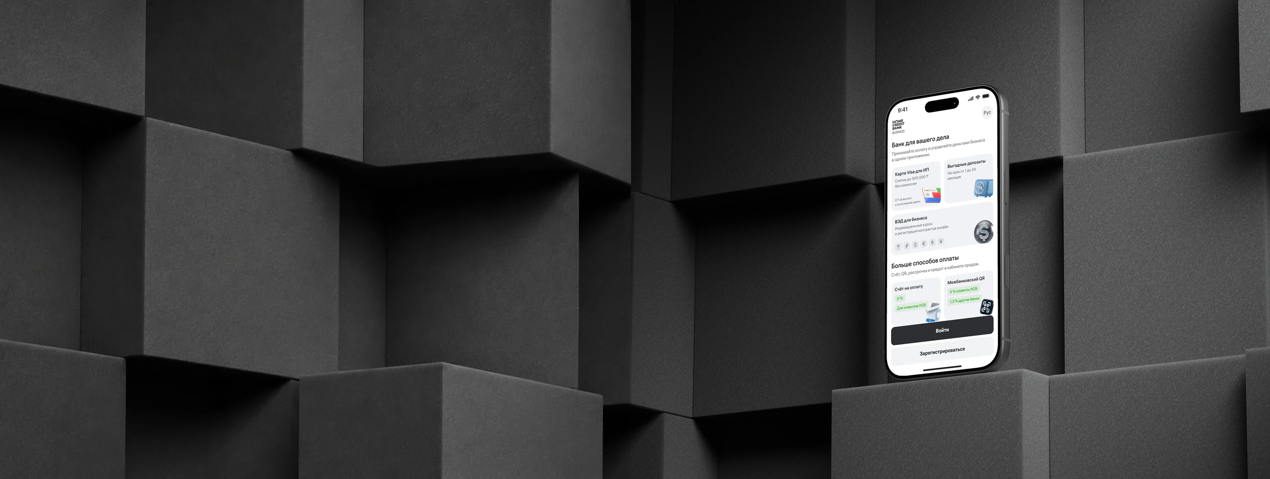 HCB Business: the business services screen on a smartphone among graphite blocks.