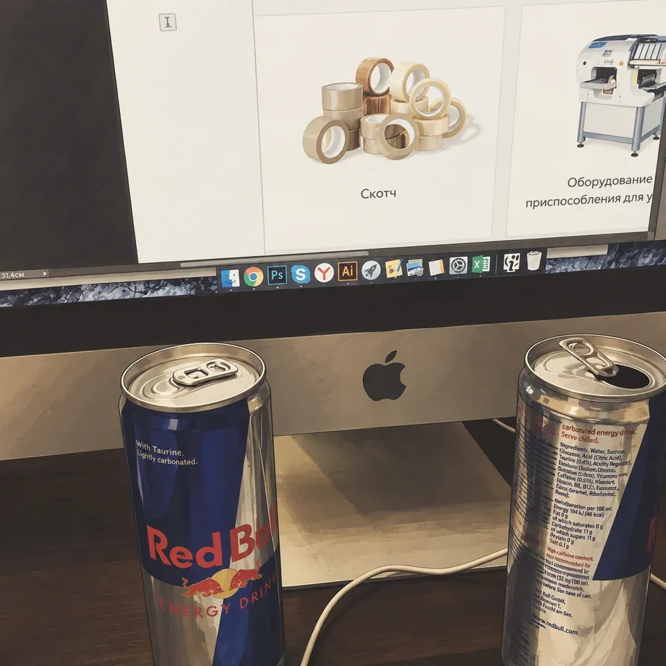 Two Red Bull cans in front of an iMac displaying an online store design.